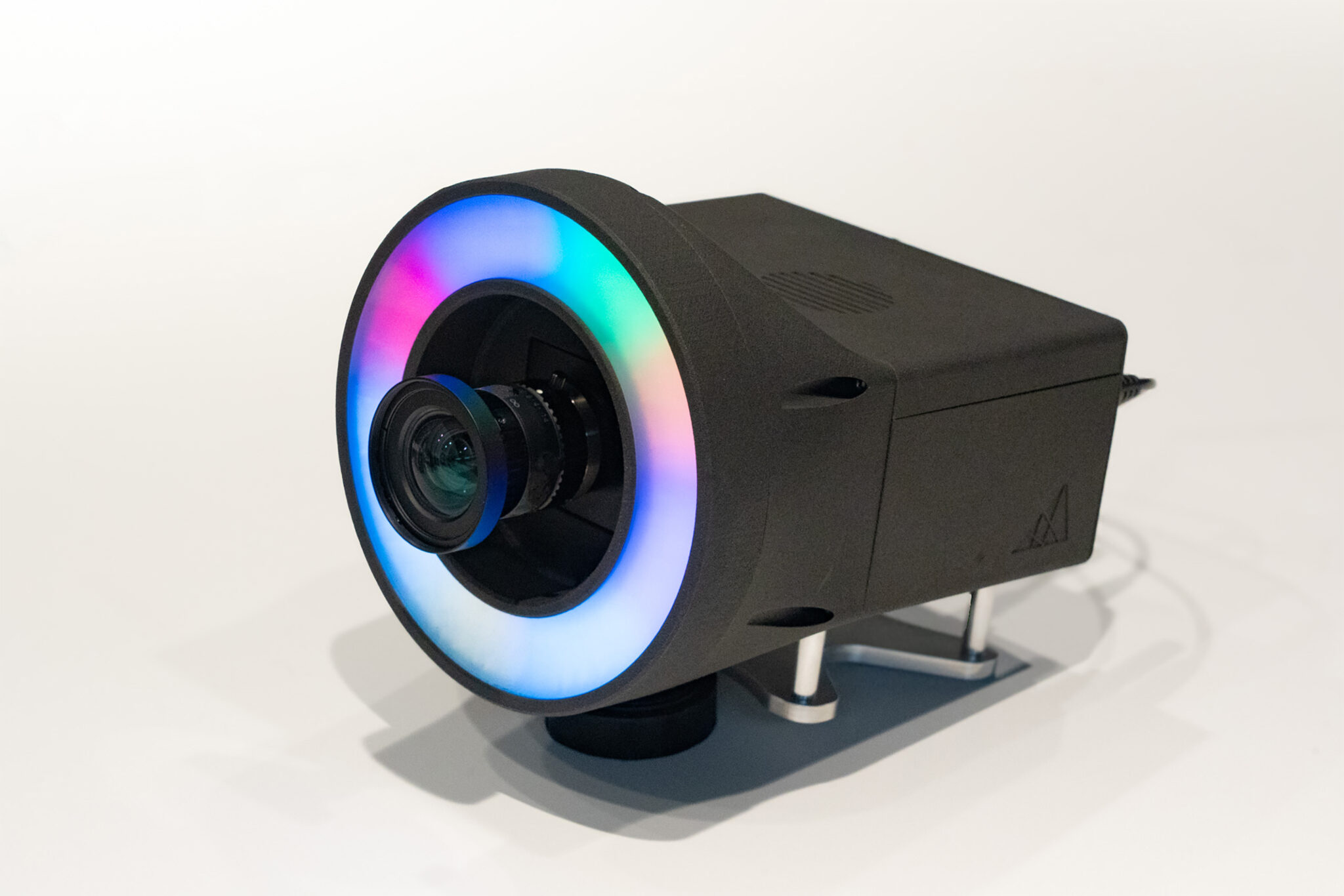AIMERAの画像。小型PCとリング型LED照明、カメラが一体となっており、照明が虹色に光っている